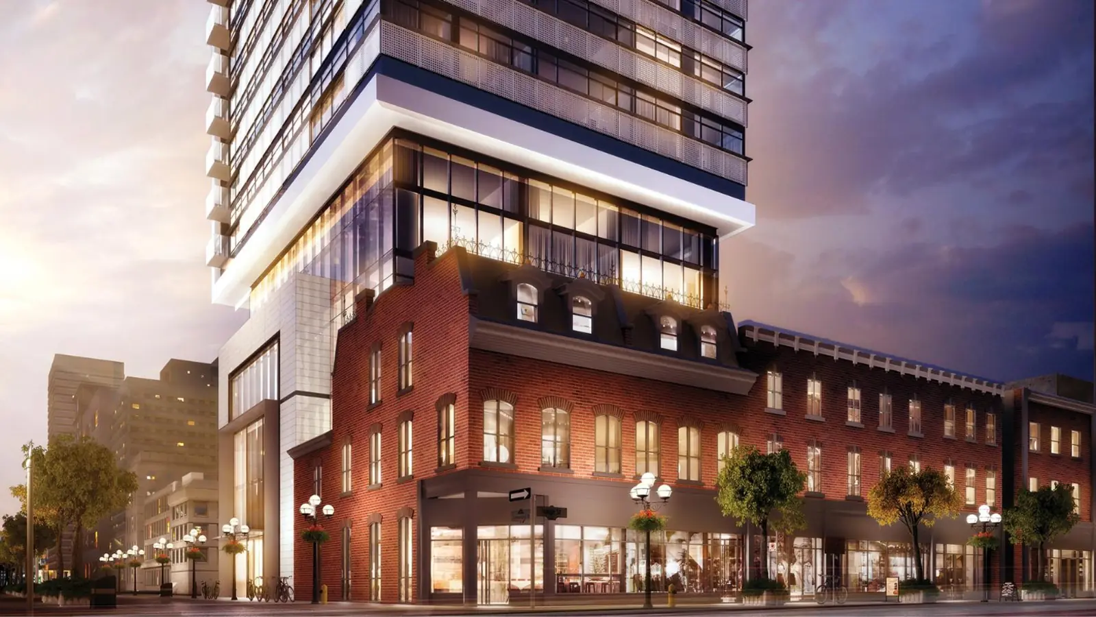 Street level view of 8 Cumberland at dusk, showing the restored red brick heritage retail base along the sidewalk with the glass tower cantilevered above it